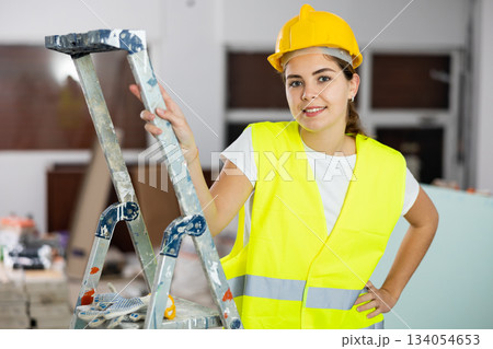 Smiling young female civil engineer standing at construction site Smiling young female civil engineer standing at construction site 134054653