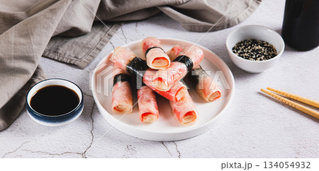 Crab sticks in rice paper with nori fried in oil on a plate on the table web banner 134054932