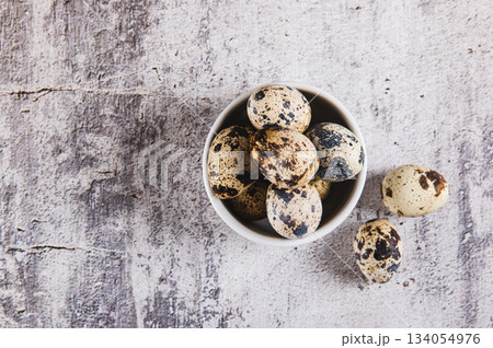 Close up of raw quail eggs in their shells in a bowl on the table top view Close up of raw quail eggs in their shells in a bowl on the table top view 134054976