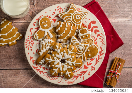 Holiday background. Christmas gingerbread cookies in different shapes in a plate Holiday background. Christmas gingerbread cookies in different shapes in a plate 134055024