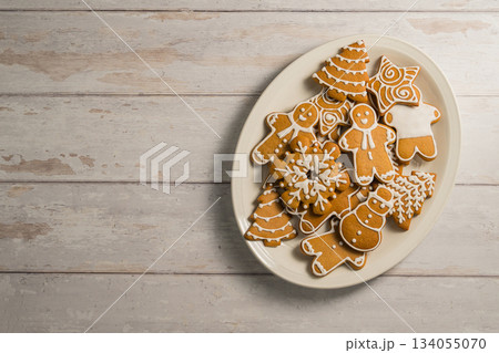 Holiday background. Christmas gingerbread cookies in different shapes in a plate, copy space Holiday background. Christmas gingerbread cookies in different shapes in a plate, copy space 134055070