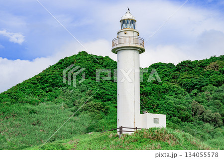 梅雨の合間に輝く石垣島御神崎灯台と緑の丘の風景 134055578