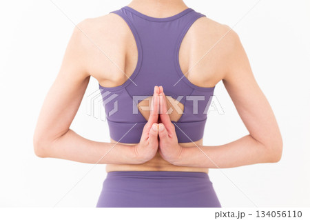 自宅でヨガをするヨガウェア姿のミドル女性 自宅でヨガをするヨガウェア姿のミドル女性 134056110