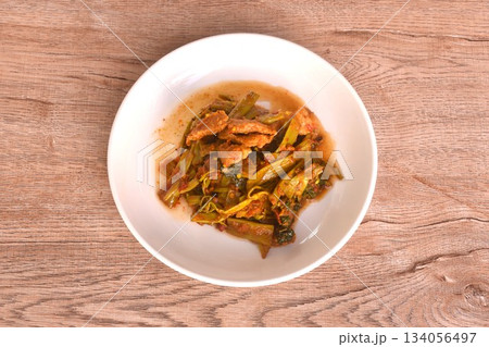 spicy stir fried Thai morning glory with slice fat pork belly in curry sauce on plate  134056497