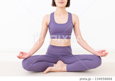 自宅でヨガをするヨガウェア姿のミドル女性 自宅でヨガをするヨガウェア姿のミドル女性 134056668
