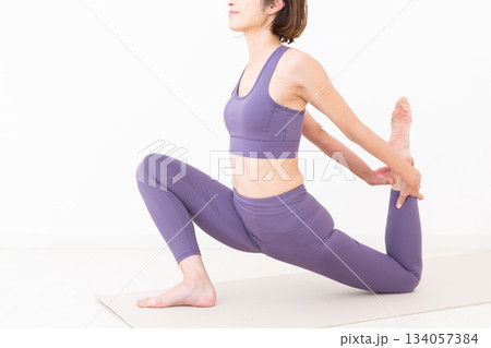 自宅でストレッチをするヨガウェア姿のミドル女性 自宅でストレッチをするヨガウェア姿のミドル女性 134057384