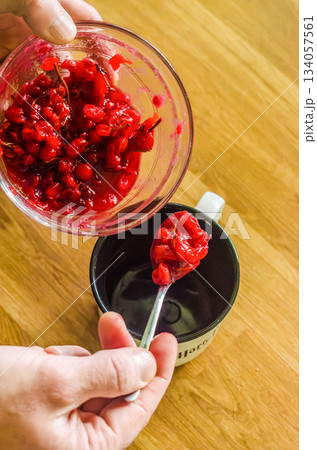 Adding viburnum Red Berry Compote Into Mug Adding viburnum Red Berry Compote Into Mug 134057561