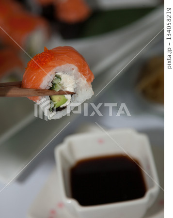 Salmon sushi set. Sushi roll Philadelphia with red fish, salmon, red caviar. Roll with soft avocado and cream cheese under a layer of massago caviar. Classic sushi. Food background. Salmon sushi set. Sushi roll Philadelphia with red fish, salmon, red caviar. Roll with soft avocado and cream cheese under a layer of massago caviar. Classic sushi. Food background. 134058219