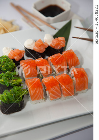 Salmon sushi set. Sushi roll Philadelphia with red fish, salmon, red caviar. Roll with soft avocado and cream cheese under a layer of massago caviar. Classic sushi. Food background. Salmon sushi set. Sushi roll Philadelphia with red fish, salmon, red caviar. Roll with soft avocado and cream cheese under a layer of massago caviar. Classic sushi. Food background. 134058221