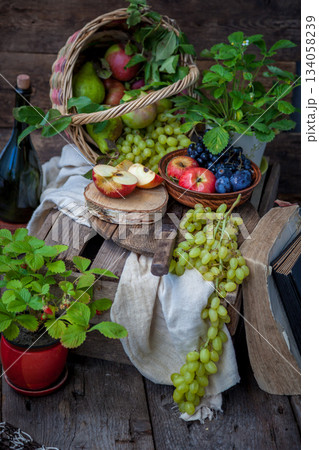 Autumn still life. Fruits and berries. Apples, grapes, strawberries, plums on a wooden table. Country style. Idle healthy vitamin food. Fruit harvest. Old knife. An apple in a basket. Autumn still life. Fruits and berries. Apples, grapes, strawberries, plums on a wooden table. Country style. Idle healthy vitamin food. Fruit harvest. Old knife. An apple in a basket. 134058239