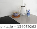 Electric kettle and ceramic mugs on minimalist kitchen counter. Contemporary home aesthetics 134059262