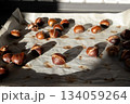 Roasted chestnuts on parchment paper close-up, homemade 134059264