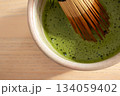 Creamy matcha tea whisked with bamboo chasen in traditional ceramic bowl. Ceremonial matcha 134059402