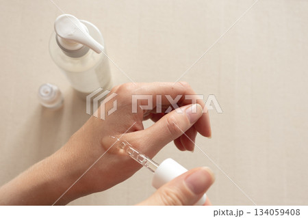 Serum application on hand with dropper, neutral minimal skincare concept 134059408
