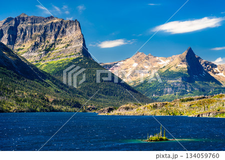 Wild Goose Island sits in blue waters of Saint Mary Lake in Glacier National Park, Montana, USA. Scenic landscape features majestic peaks and pine trees in UNESCO World Heritage site Wild Goose Island sits in blue waters of Saint Mary Lake in Glacier National Park, Montana, USA. Scenic landscape features majestic peaks and pine trees in UNESCO World Heritage site 134059760