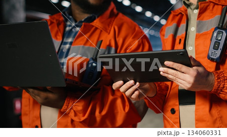 Employees team guide assembly and fabrication duties in a warehouse facility, emphasizing professional steel production and the precision needed for the manufacturing process. Employees team guide assembly and fabrication duties in a warehouse facility, emphasizing professional steel production and the precision needed for the manufacturing process. 134060331