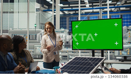 Photovoltaics plant researchers doing meeting, looking at chroma key monitor, evaluating energy production. Experts optimize factory gear energy output, looking at isolated screen display, camera A 134060386
