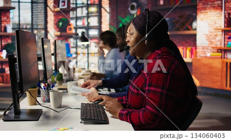 Senior account manager teaching intern how to talk with customers to identify sales opportunities. Experienced team leader helping new trainee in office to generate leads, camera B 134060403