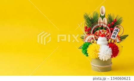 黄色背景に鏡餅が置かれた余白付きの正月飾りミニマルスタイル写真 134060621