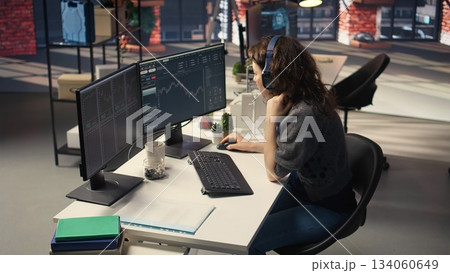 Financial investor works on PC analyzing stock market trends. The digital interface displays price fluctuations, candlestick charts. Liquidity statistics helps strategize future trading decisions 134060649