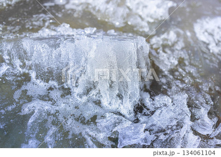 Ice formations on water surface with bubbles and textured patterns 134061104