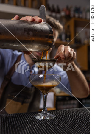Bartender pouring espresso martini cocktail 134061763