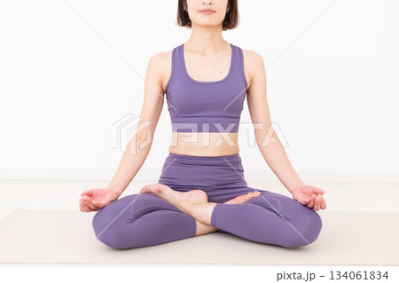 自宅でヨガをするヨガウェア姿のミドル女性 自宅でヨガをするヨガウェア姿のミドル女性 134061834