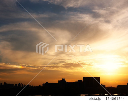 夕日に照らされる雲と街のシルエット 夕日に照らされる雲と街のシルエット 134061844