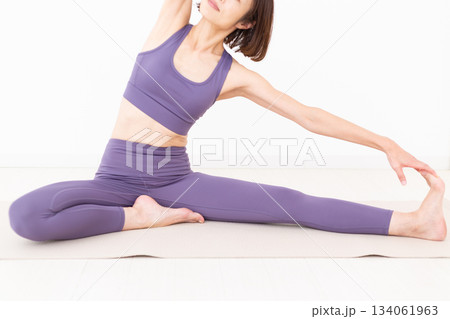 自宅でストレッチをするヨガウェア姿のミドル女性 134061963