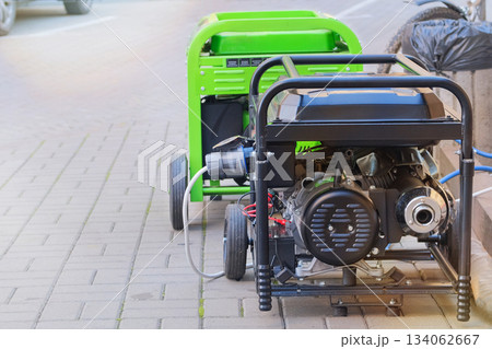 Diesel power generator. Business uses two mobile generators. Outdoor power supply generator placed on street sidewalk. Energy independence. Diesel power generator. Business uses two mobile generators. Outdoor power supply generator placed on street sidewalk. Energy independence. 134062667