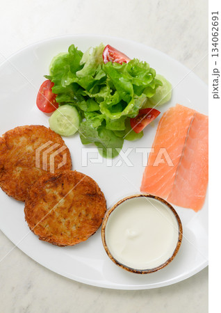 Two golden potato pancakes with salmon salad and sour cream Two golden potato pancakes with salmon salad and sour cream 134062691