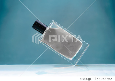 Suspended glass perfume bottle on blue background color of the year 2026 cloud white dancer 134062762