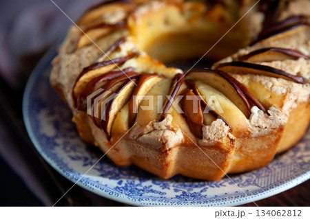 Round apple pie. Homemade pastries. Cupcake with apples on a wooden table. Simple food. Round apple pie. Homemade pastries. Cupcake with apples on a wooden table. Simple food. 134062812
