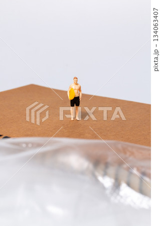 Tiny Surfer on Notebook Near Plastic Sheet Tiny Surfer on Notebook Near Plastic Sheet 134063407