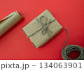 Packing of New Year's gifts Gift, twine, paper on a red background. 134063901