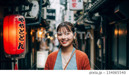 路地を歩く女性 134065540