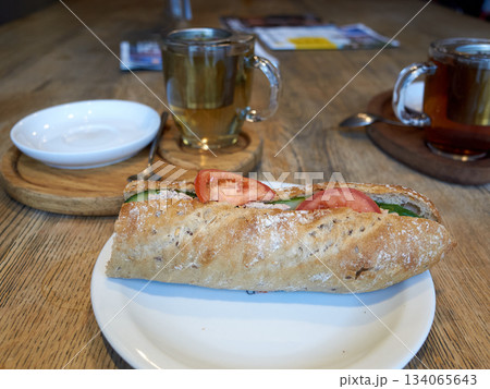 aromatic herbed bread accompanied by fresh tomatoes and leafy greens on charming white dish 134065643