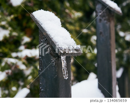 Closeup of icy ornament on metal fence in winter ambiance Closeup of icy ornament on metal fence in winter ambiance 134065659