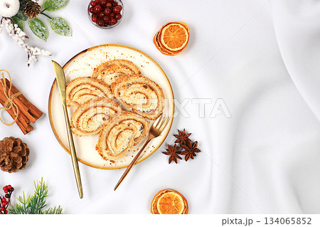 Festive Kitchen Banner.The concept of festive pastries.Homemade winter dessert, stollen, rolls or strudel with sweet cream filling, nuts, cinnamon, cranberries and poppy seeds, and eggnog. Festive Kitchen Banner.The concept of festive pastries.Homemade winter dessert, stollen, rolls or strudel with sweet cream filling, nuts, cinnamon, cranberries and poppy seeds, and eggnog. 134065852