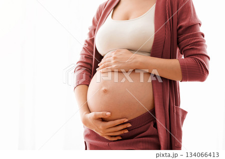 Unrecognizable Pregnant Lady Touching Her Naked Belly, Closeup Shot. Expectant Mother Standing Against Window At Home And Tenderly Embracing Tummy, Enjoying Pregnancy Time, Cropped Image, Copy Space Unrecognizable Pregnant Lady Touching Her Naked Belly, Closeup Shot. Expectant Mother Standing Against Window At Home And Tenderly Embracing Tummy, Enjoying Pregnancy Time, Cropped Image, Copy Space 134066413