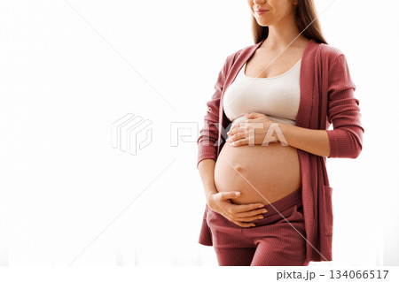 Maternity Concept. Portrait Of Young Beautiful Pregnant Lady Standing Near Window At Home, Dreamy Expectant Woman Tenderly Embracing Her Naked Belly And Smiling, Enjoying Prenatal Time, Copy Space Maternity Concept. Portrait Of Young Beautiful Pregnant Lady Standing Near Window At Home, Dreamy Expectant Woman Tenderly Embracing Her Naked Belly And Smiling, Enjoying Prenatal Time, Copy Space 134066517