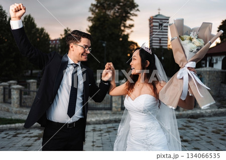 Happy multicultural wedding couple dancing celebrating marriage Happy multicultural wedding couple dancing celebrating marriage 134066535