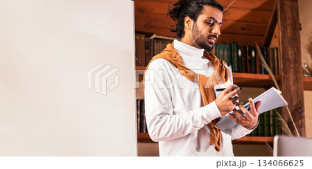 E-Teaching. Indian Teacher Man Standing Near Laptop And Blackboard Having Distant Online Class Indoors. Modern Remote Teaching, Internet Education. Selective Focus 134066625