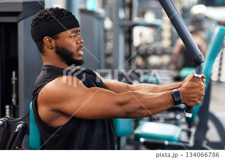 Side view of black guy bodybuilder making work out for shoulders and chest muscles at gym, copy space. Concentrated african american man exercising on pec deck machine, closeup Side view of black guy bodybuilder making work out for shoulders and chest muscles at gym, copy space. Concentrated african american man exercising on pec deck machine, closeup 134066786