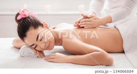 Beautiful Asian Woman Lying On Spa Bed, Getting Back Massage Treatment From Professional Masseur In Beauty Salon, Relaxed Korean Lady Enjoying Body Care And Self-Pampering, Side View With Free Space Beautiful Asian Woman Lying On Spa Bed, Getting Back Massage Treatment From Professional Masseur In Beauty Salon, Relaxed Korean Lady Enjoying Body Care And Self-Pampering, Side View With Free Space 134066884