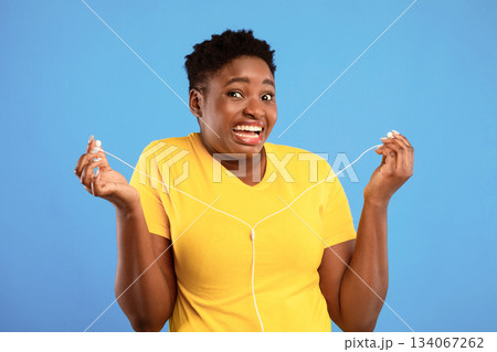 Auwful Playlist. Funny Black Lady Holding Earphones Not Liking Music Standing Over Blue Studio Background, Looking At Camera In Disgust. I Don't Want To Hear It Concept Auwful Playlist. Funny Black Lady Holding Earphones Not Liking Music Standing Over Blue Studio Background, Looking At Camera In Disgust. I Don't Want To Hear It Concept 134067262