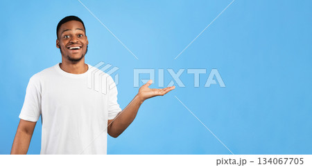 Look At This. Cheerful African American Guy Showing Free Space For Text Gesturing Aside Standing On Blue Background. Studio Shot 134067705