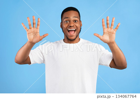 Joyful Black Man Showing Number Ten With Both Hands Smiling To Camera Posing Over Blue Background. Studio Shot Joyful Black Man Showing Number Ten With Both Hands Smiling To Camera Posing Over Blue Background. Studio Shot 134067764