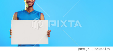 Sport Advertisement. Unrecognizable Athlete Holding Blank White Board Advertising Gym Over Blue Studio Background. Cropped, Mockup, Panorama Sport Advertisement. Unrecognizable Athlete Holding Blank White Board Advertising Gym Over Blue Studio Background. Cropped, Mockup, Panorama 134068129