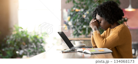 Exhausted african american girl sitting in cafe, looking for job online, using laptop, empty space Exhausted african american girl sitting in cafe, looking for job online, using laptop, empty space 134068173